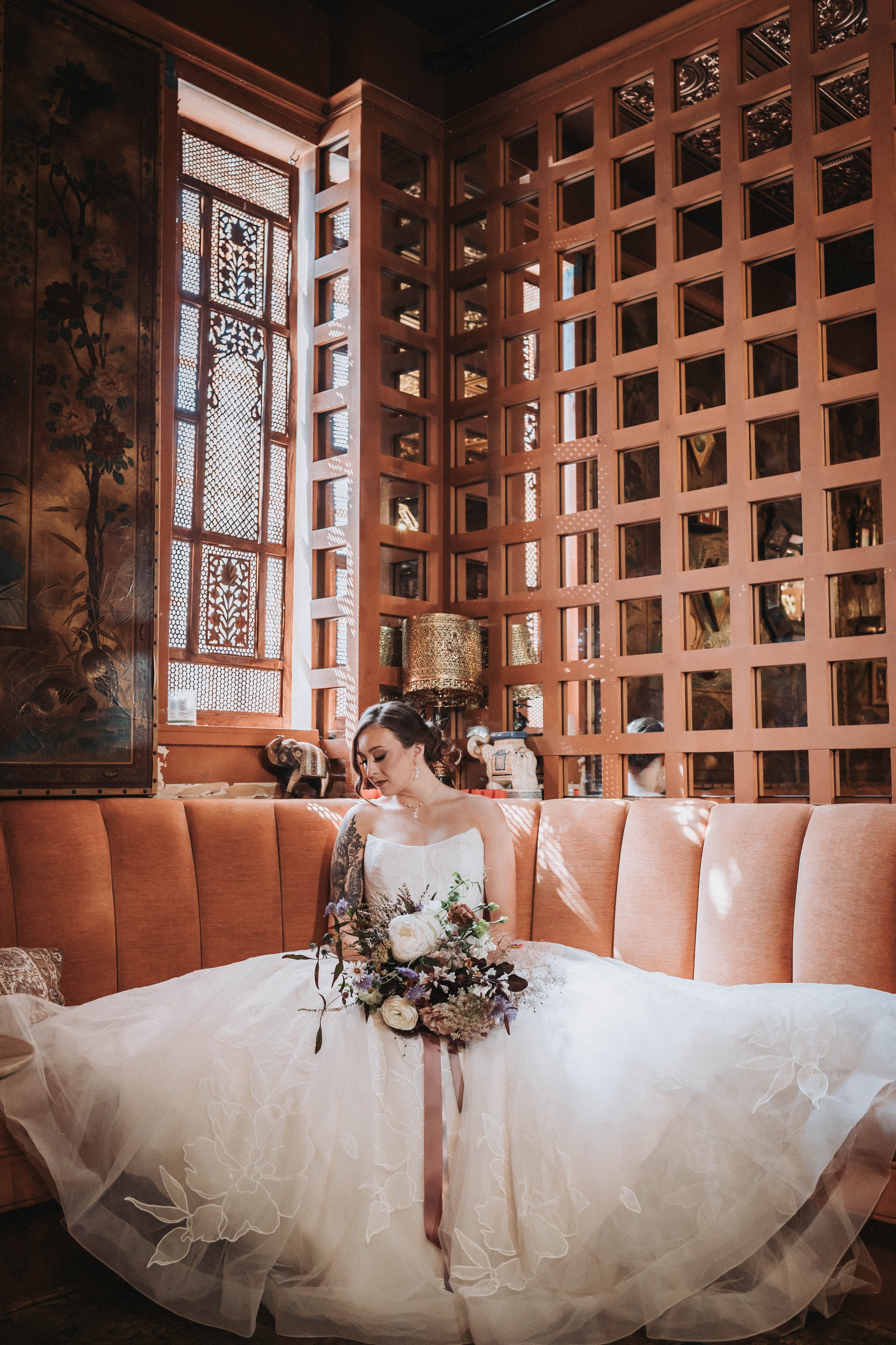 Bride seated alone with her bouquet on a velvet banquette before the ceremony — Seattle, Washington wedding photography