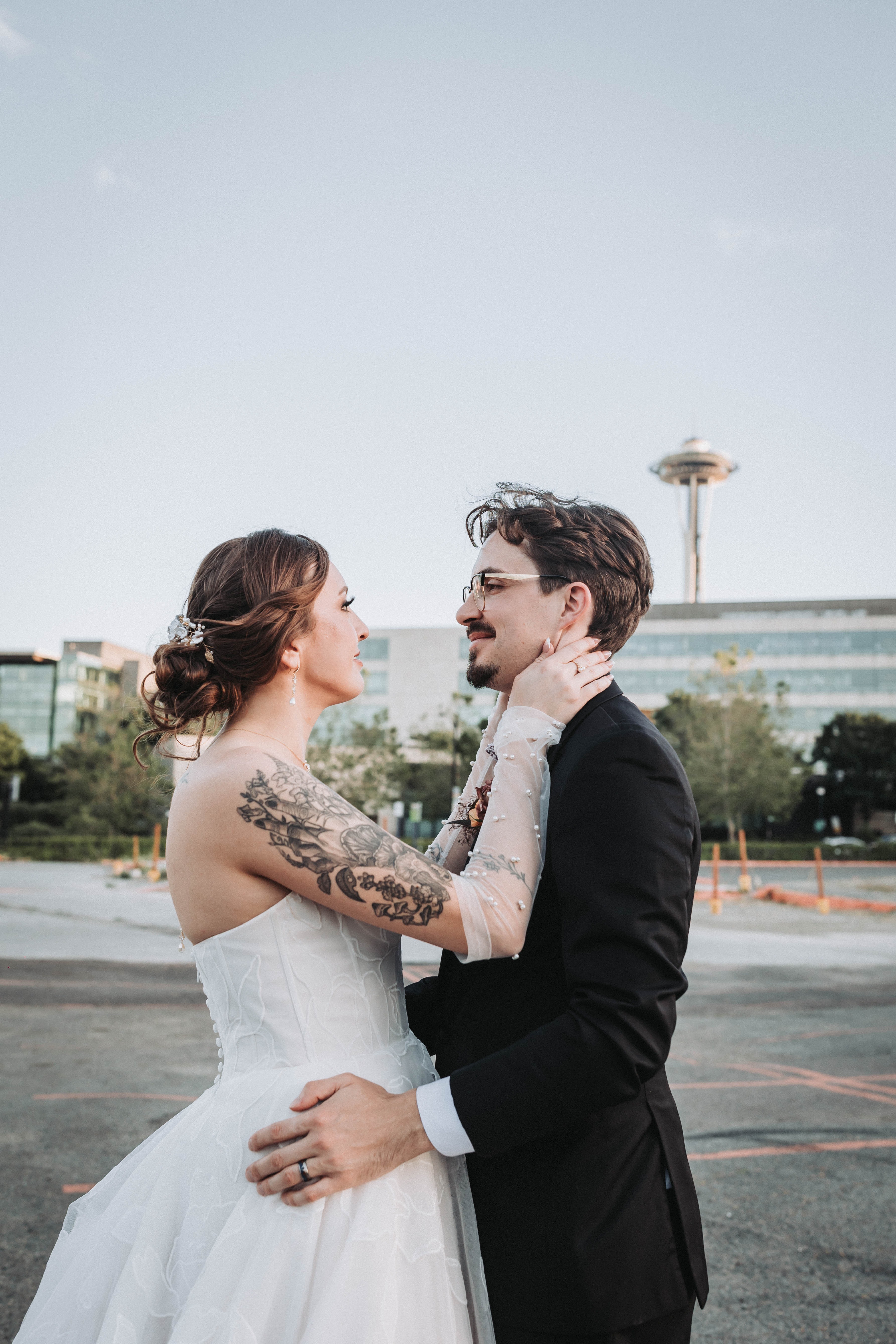 Couple embracing outdoors at dusk with the Space Needle behind them — Seattle, Washington wedding photography